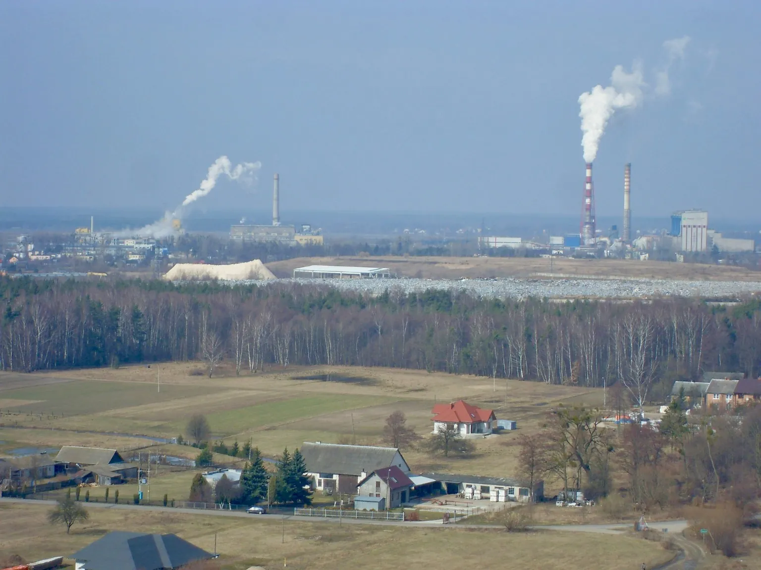 Rozległy krajobraz przemysłowy z kominami